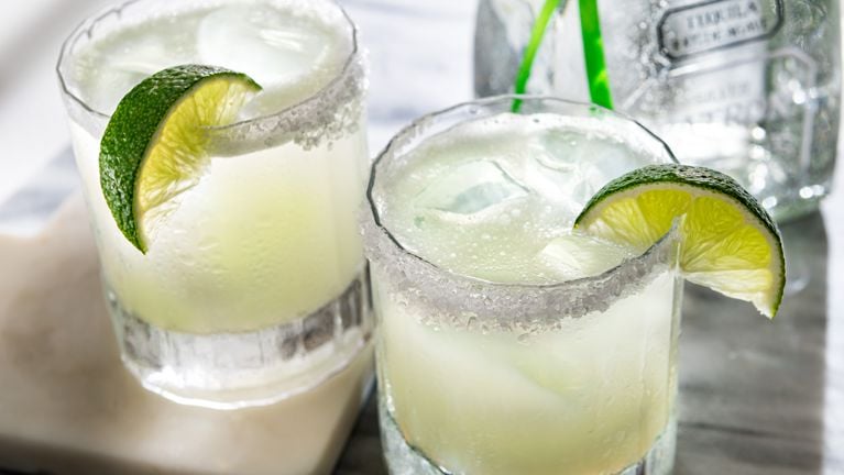 Two classic margaritas made with Patron tequila in lowball glasses.