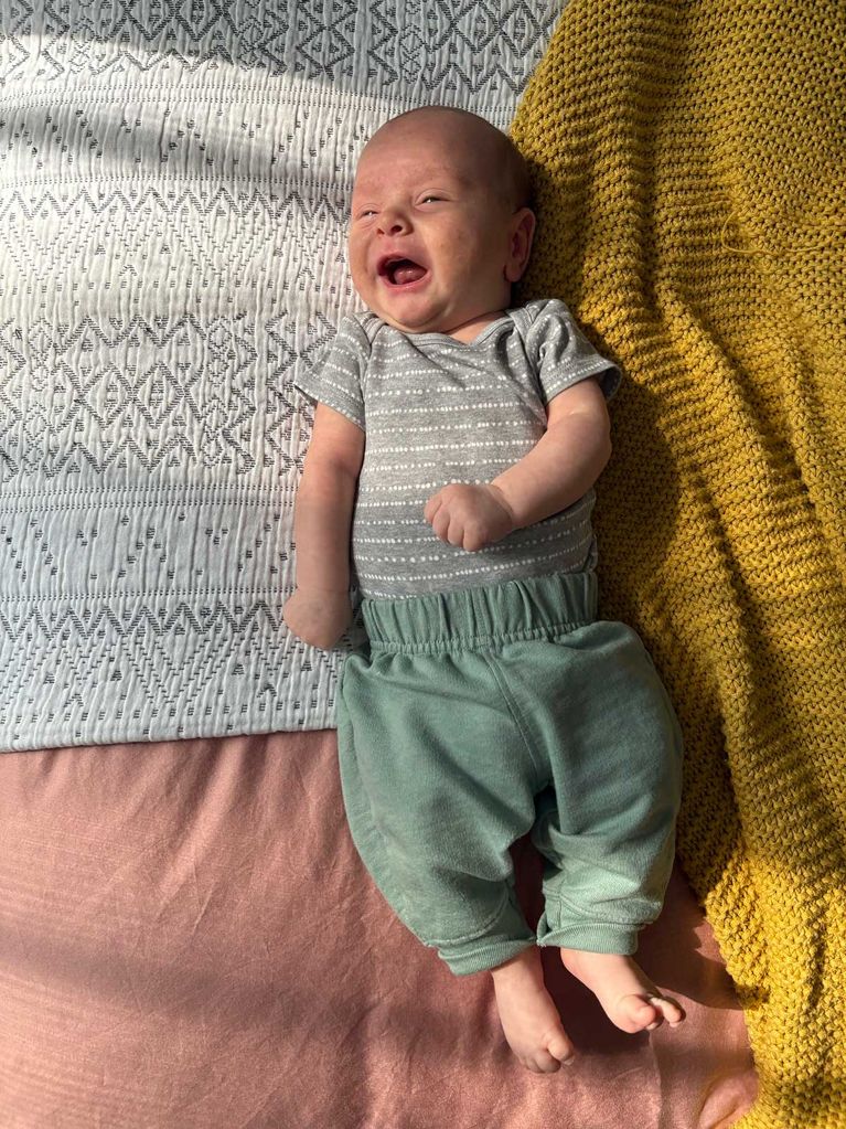 Photo of a baby on a bed with a yellow and white blanket, for a story about taking better photos with your iPhone.