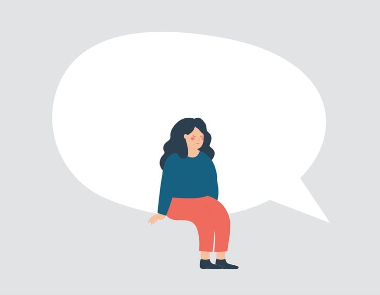 Woman sits on a large empty speech bubble.