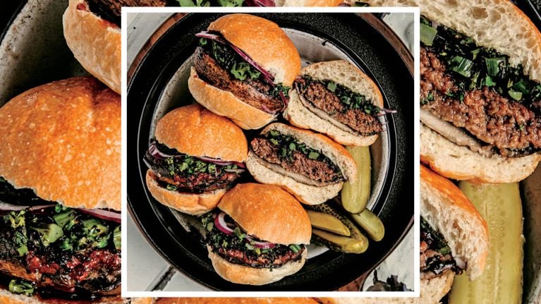 A plate of hoisin portobello burgers, with a side of pickles.