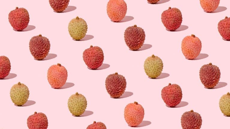 A photo of lychee fruits on a pink background for an article about how to treat keratosis pilaris.