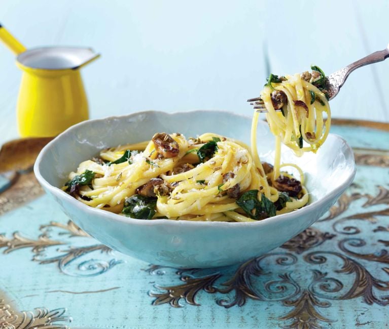 an archival photo of lemon linguine with smoked oysters, with a fork hoisting the pasta out of the plate