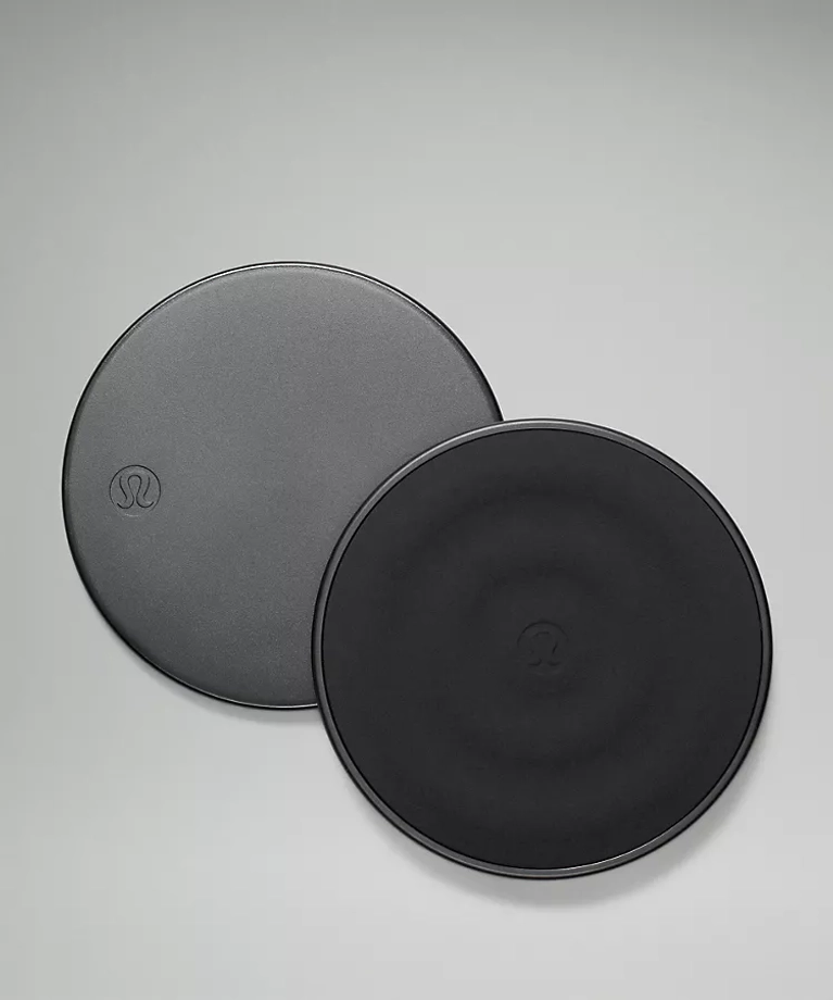 A pair of black circular exercise sliders.
