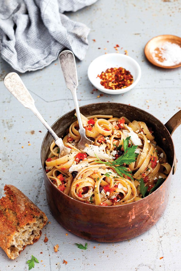 a pot of mediterranean fettucine, made with fettuccine; 2 cooked haddock fillets; olive oil; garlic; white wine; Tomato Relish; chopped parsley; and lemon for a post on an easy two-for-one dinner recipe of mediterranean haddock fettucine