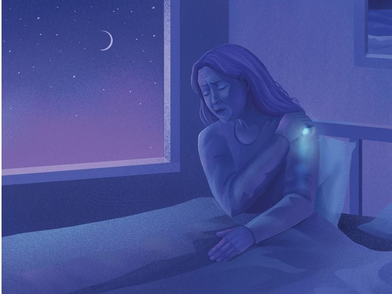 An illustration of a woman sitting in bed with a starry sky and crescent moon outside gripping her shoulder as a ball of light representing pain radiates down her arm to represent frozen shoulder for a piece on what is frozen shoulder