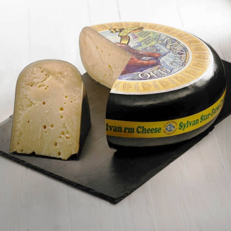 A wheel of gouda with a slice cut out.
