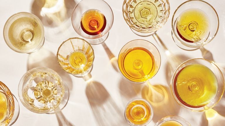A selection of various cooking oils poured into different clear glasses.