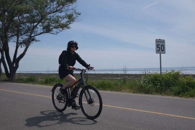 A woman biking on the coast of the L’Isle-aux-Coudres island in Charlevoix, Quebec