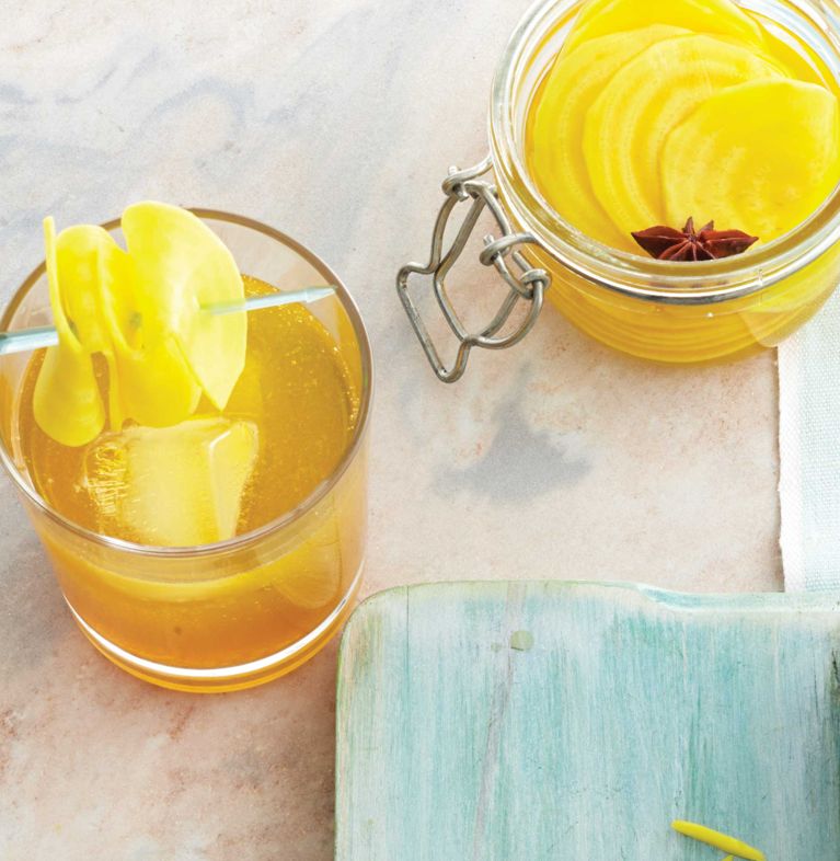 A brandied beet shrub cocktail made with pickled yellow beets, apple brandy, ginger juice, simple syrup and garnished with pickled yellow beets for a post on an easy beet shrub cocktail recipe