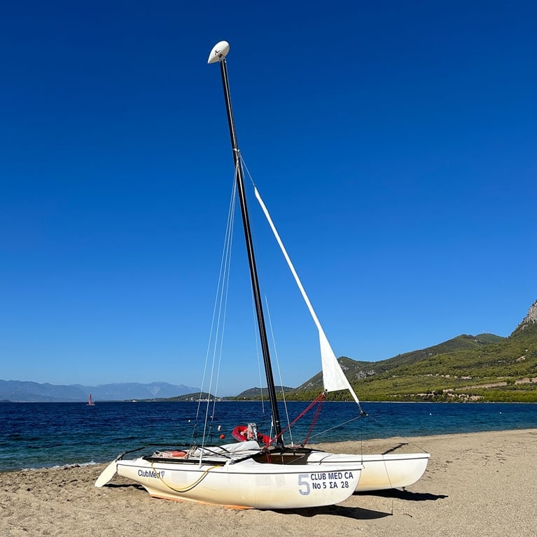 A photo of a sailing catamaran on a beach for a review of the Club Med Gregolimano resort in Greece.