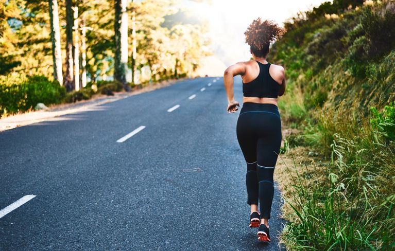 How to start running if you have never run before: A white-haired woman jogging on a trail