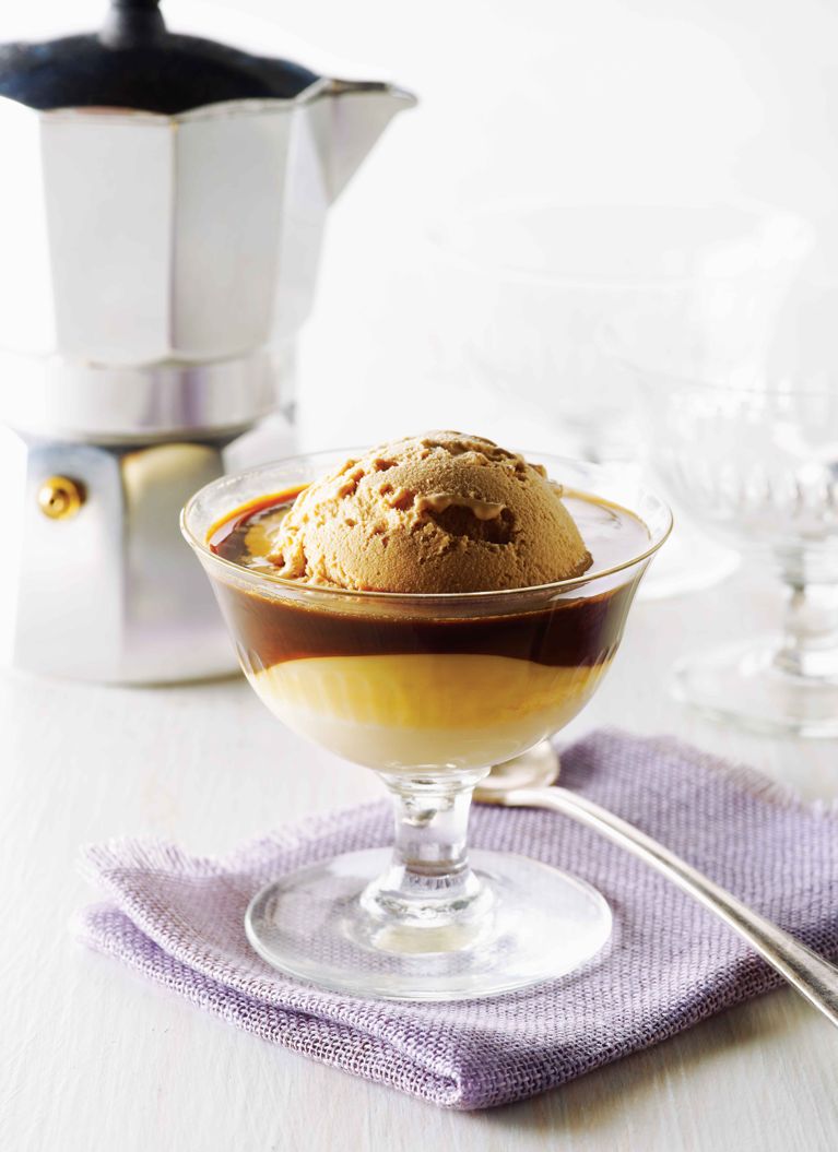 Vietnamese espresso affogato in a glass coupe bowl next to an espresso maker. The affogatto is made with coffee ice cream; sweetened condensed milk and hot espresso for a post on an easy Vietnamese espresso affogatto recipe