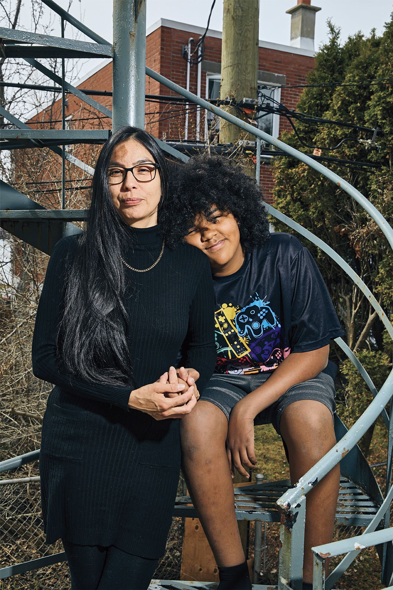 Sheri Pranteau poses on a spiral staircase next to her son, Neville, in the backyard of their home in Montreal.