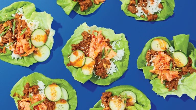 A series of lettuce wraps filled with cooked ground plant-base protein and rice.