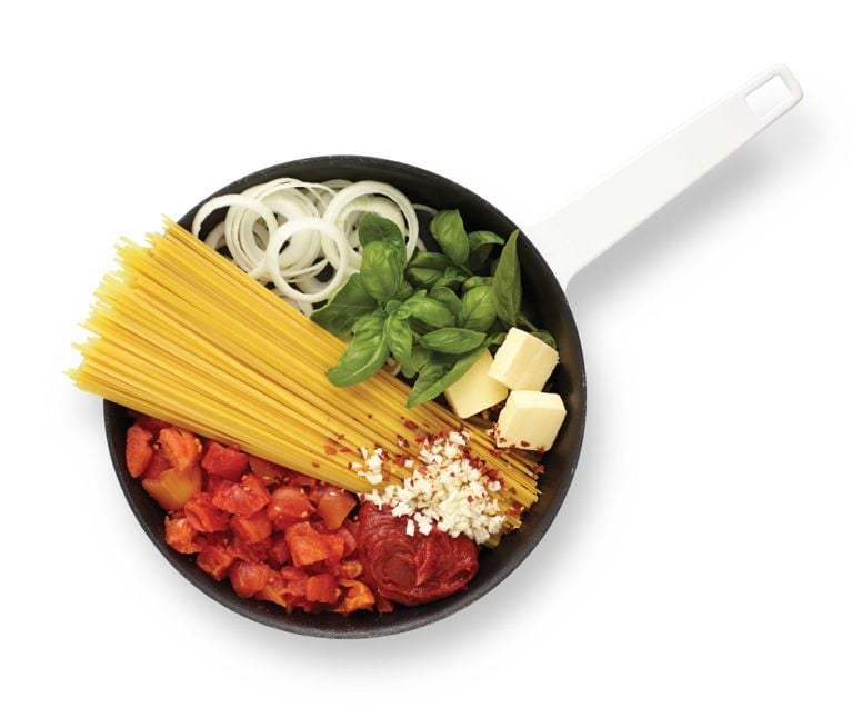 A deep skillet pan with spaghetti; diced tomatoes; fresh basil; onion and parmesan and tomato paste resting in it for a post on an easy one-pan pasta with tomato sauce recipe