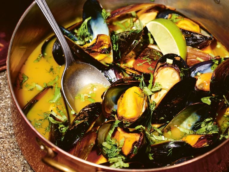 A copper stock pot filled with freshly cooked mussels in a light green curry sauce from Vikram Vij's new cookbook, My New Indian Kitchen.