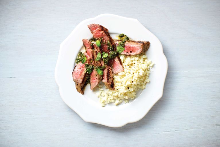 Grilled steak with spicy cilantro sauce next to cauliflower "rice," for a post on an easy and healthy Grilled steak with spicy cilantro sauce and cauliflower rice weeknight dinner recipe
