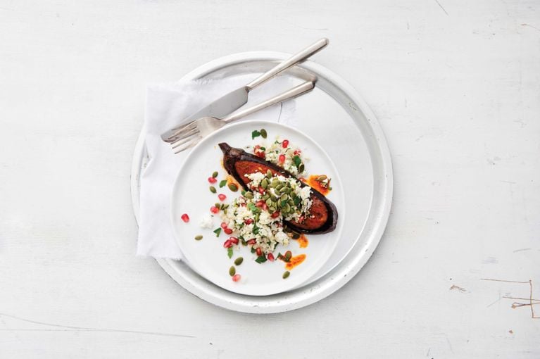 Eggplant steaks with cauliflower pilaf garnished with pumpkin and pomegranate seeds for a post on an easy Eggplant steaks with cauliflower pilaf for a weeknight dinner recipe