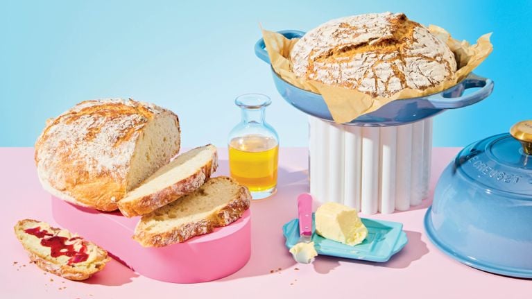 An assortment of no-knead loaves of bread on a blue and pink backdrop