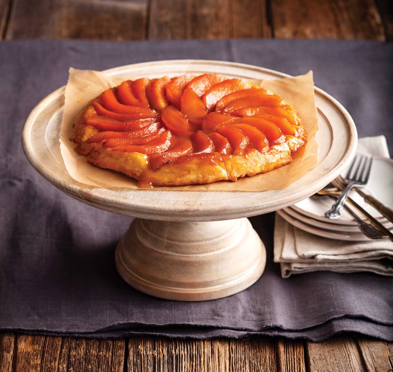 A quince or apple tarte tatin on a pottery cake stand for a post on the best quince or apple tarte tatin recipe