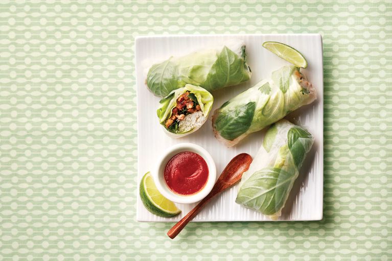 Thai chicken rice noodle rolls on a white square plate; made with fine rice vermicelli noodles; lime juice; leftover chicken and kale; rice paper; lettuce; cilantro; basil and sriracha for a post on an easy weeknight fine rice vermicelli noodles recipe