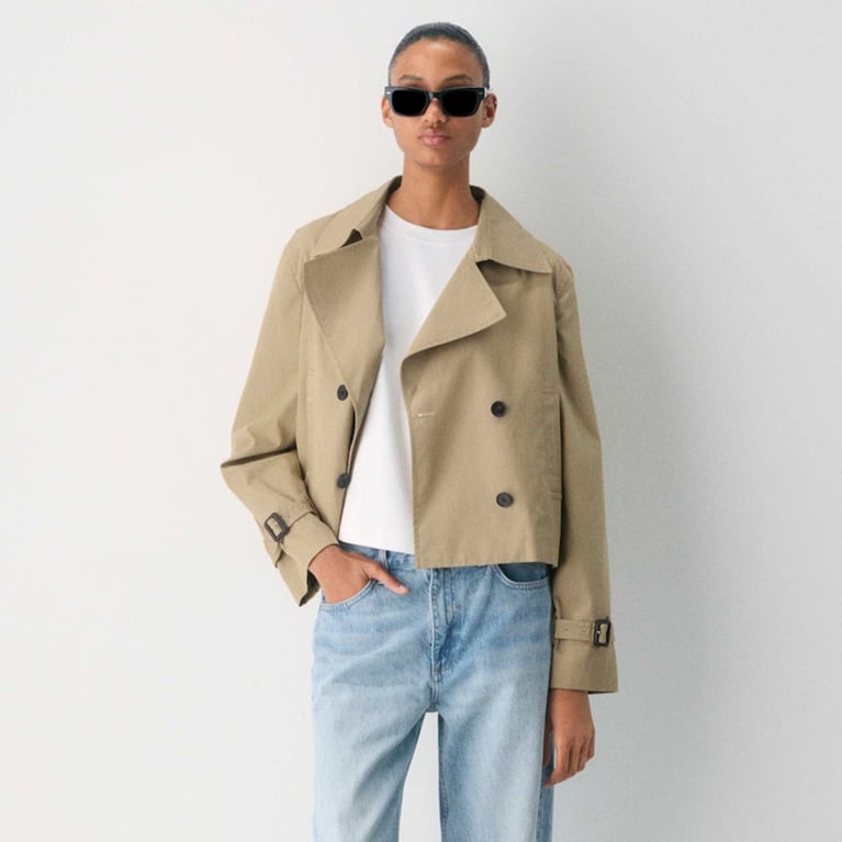 A model wearing a beige Aritzia cropped trench coat for an article about updated basics for fall 2025.