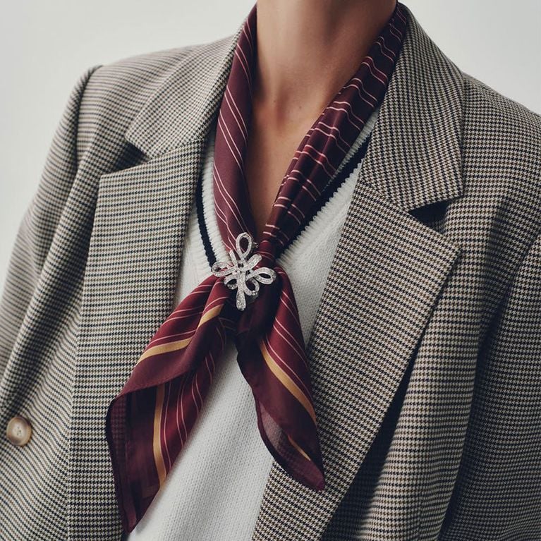 A model wearing a Reitmans burgundy striped scarf for an article about updated basics for fall 2025.
