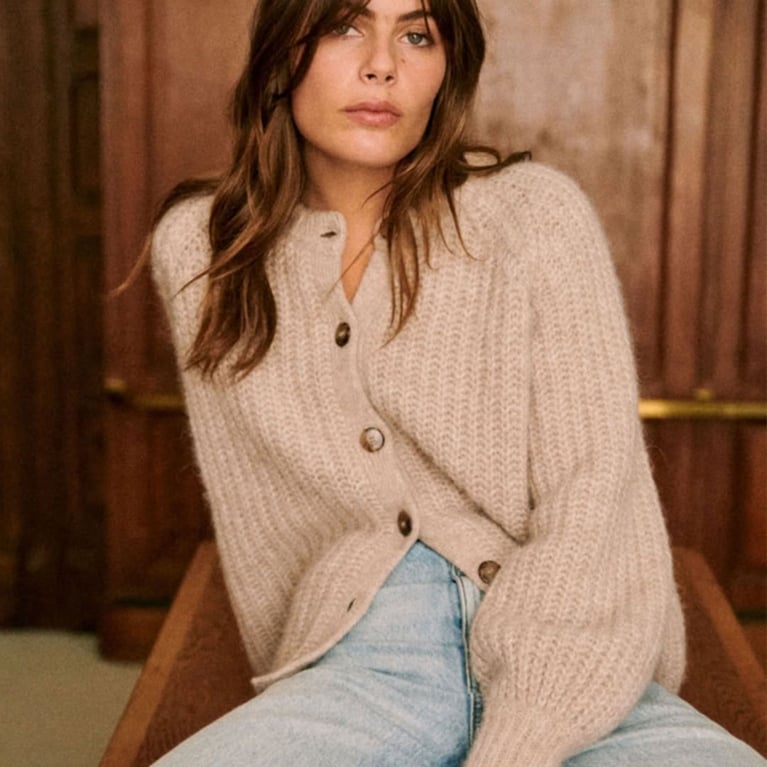 A model wearing a beige Sézane cardigan for an article about updated basics for fall 2025.