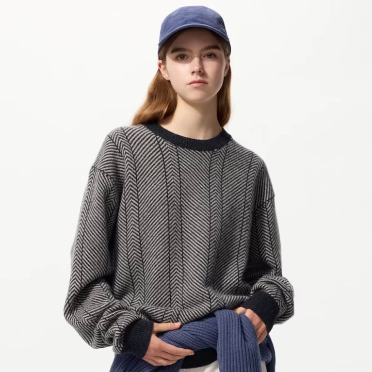 A model wearing a Uniqlo x JW Anderson Lambswool Herringbone Crewneck Sweater for an article about the best purchases our editors made in October 2025.