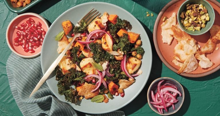 A bowl of roasted chickpeas, sweet potato, red onion and kale.