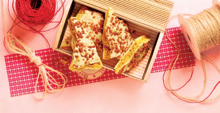 a box of double caramel sponge candy next to string and wrapping paper for an easy gift double caramel sponge candy recipe