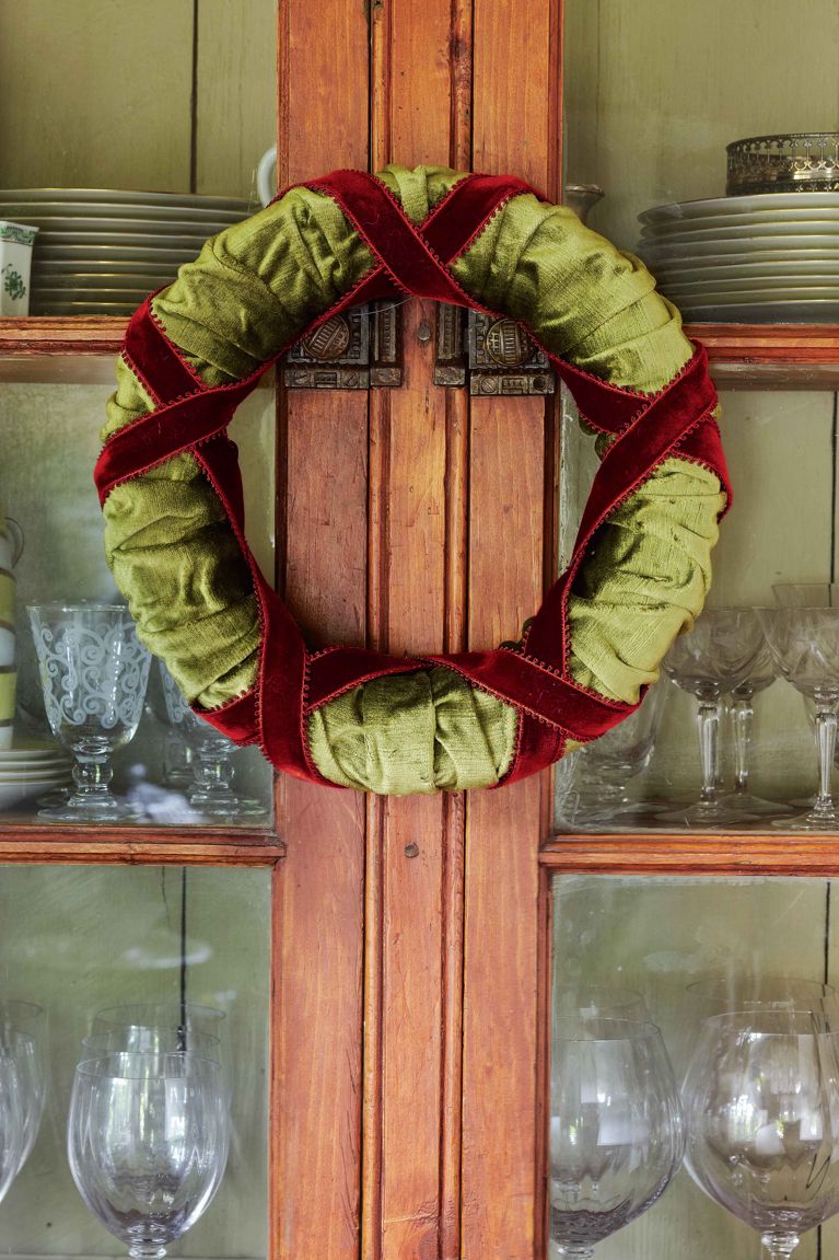 A homemade wreath made from leftover green fabric scraps and red velvet ribbon