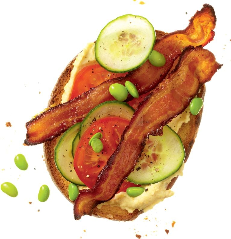 A modern BLT sandwich with white bean-wasabi hummus; edamame beans and english cucumber on rye bread for a post on an delicious modern BLT sandwich recipe