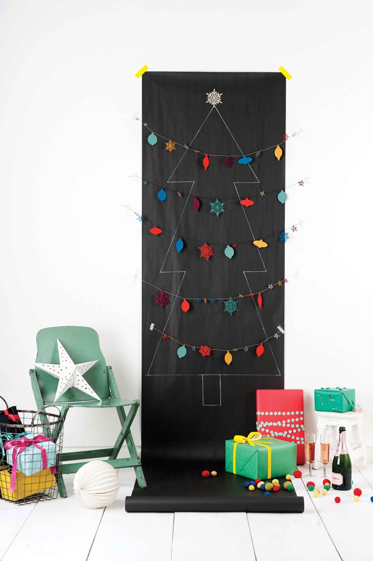 A paper christmas tree on black kraft paper decorated with homemade garlands