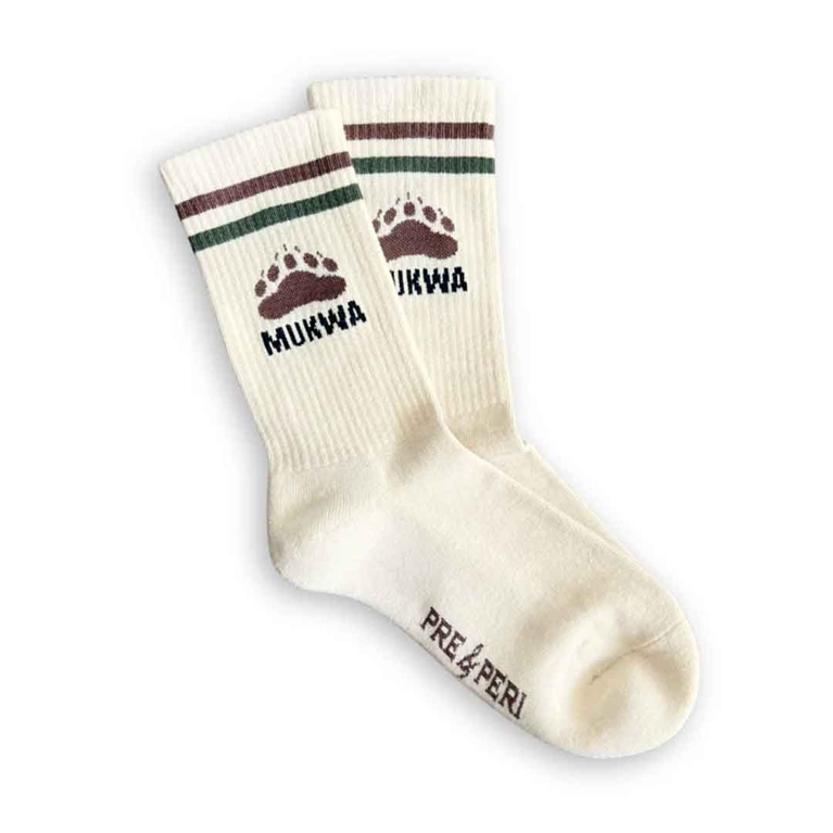 A pair of Pre & Peri socks with a bear print and the word "mukwa" and green and brown stripes