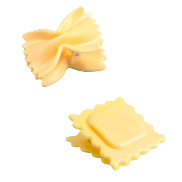 Two plastic chip clips in the shape of different pasta: farfalle and ravioli