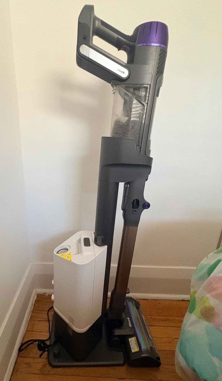 A Shark stick vacuum in its docking station in a post about best stick vacuum dog.