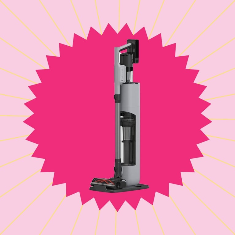 A Tineco vacuum in its charging dock in a pink graphic starburst for a post on best stick vacuums dog.