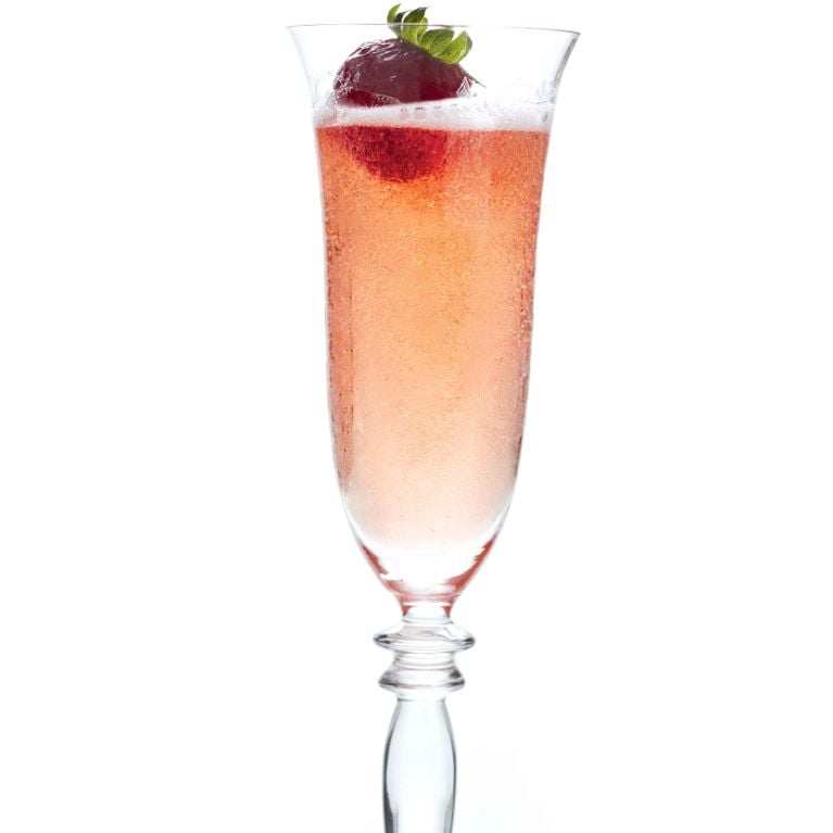 Festive Fizz Cocktail in a champagne flute, a pink sparkling drink made with Champagne, Strawberry Liqueur (like Fragoli), and Cointreau orange liqueur, garnished with a fresh whole strawberry.
