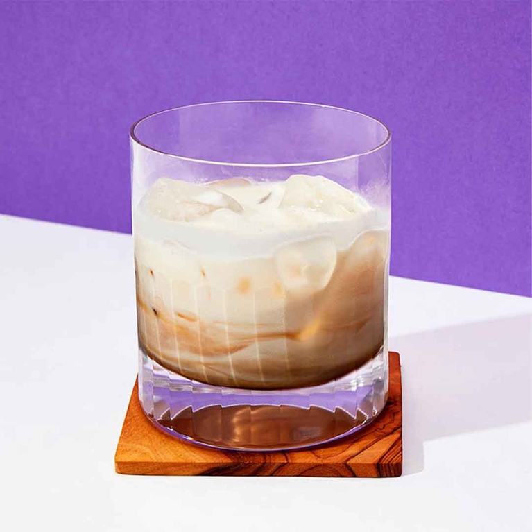 A rocks glass with an eggnog white russian in it.