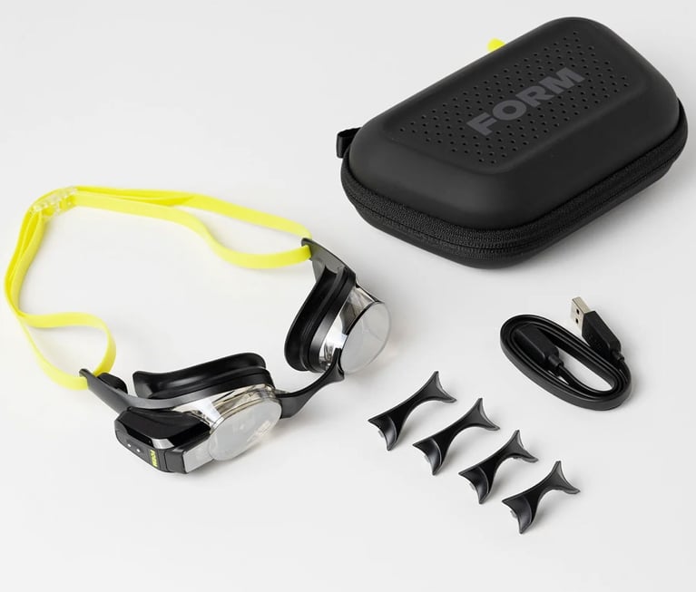 A pair of swim goggles with a carrying case and USB adaptor in a post about best fitness gifts.