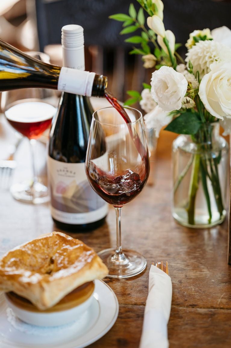 A bottle of red wine at the Grange winery being poured into a bottle