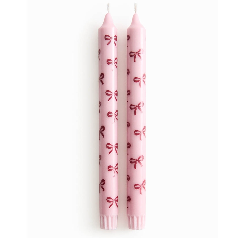 A set of two pink candles with bows for an article about the best H&M Home holiday decor pieces for 2025.