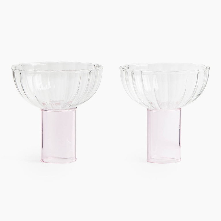 Two cocktail coupes with pink bases for an article about the best H&M Home holiday decor pieces for 2025.