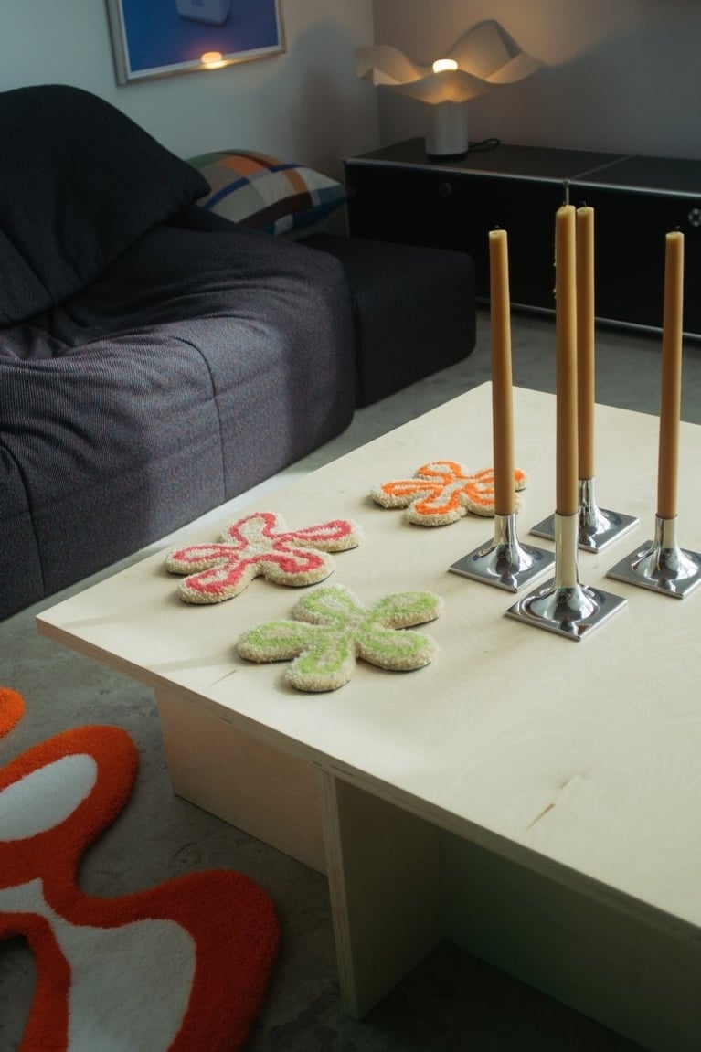 Three tufted floral coasters or placemats in orange, green and pink made by Rashelle