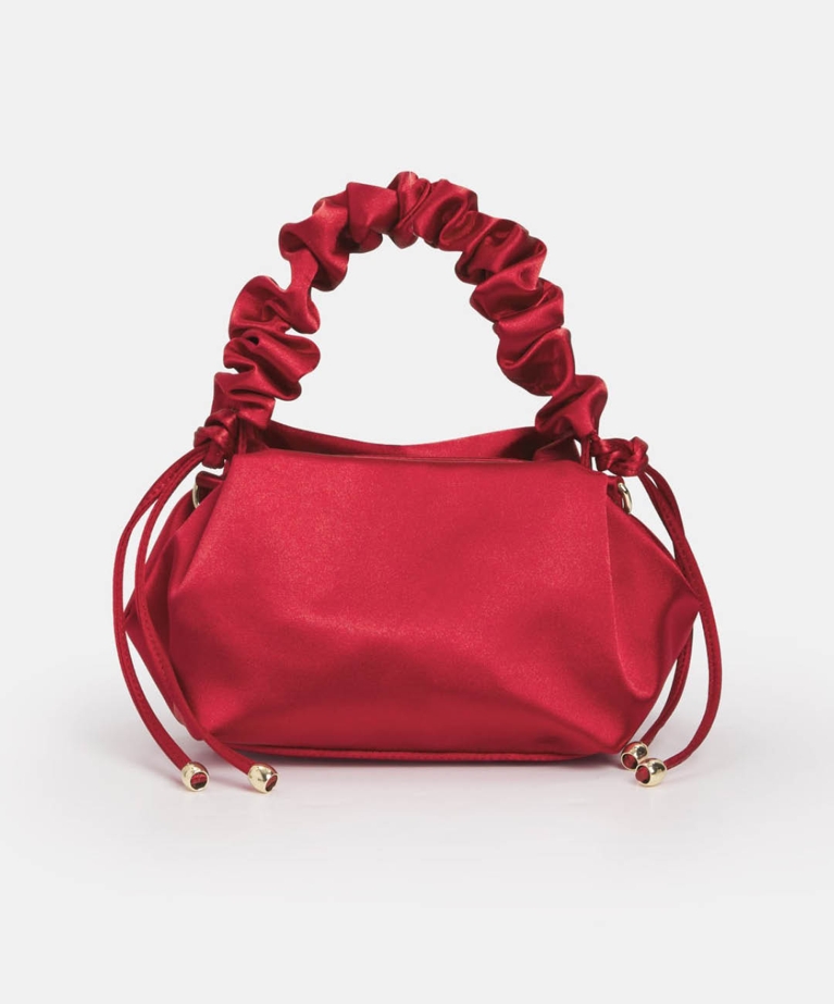 A red ruched top handle bag from the Melanie Lyne holiday collection.