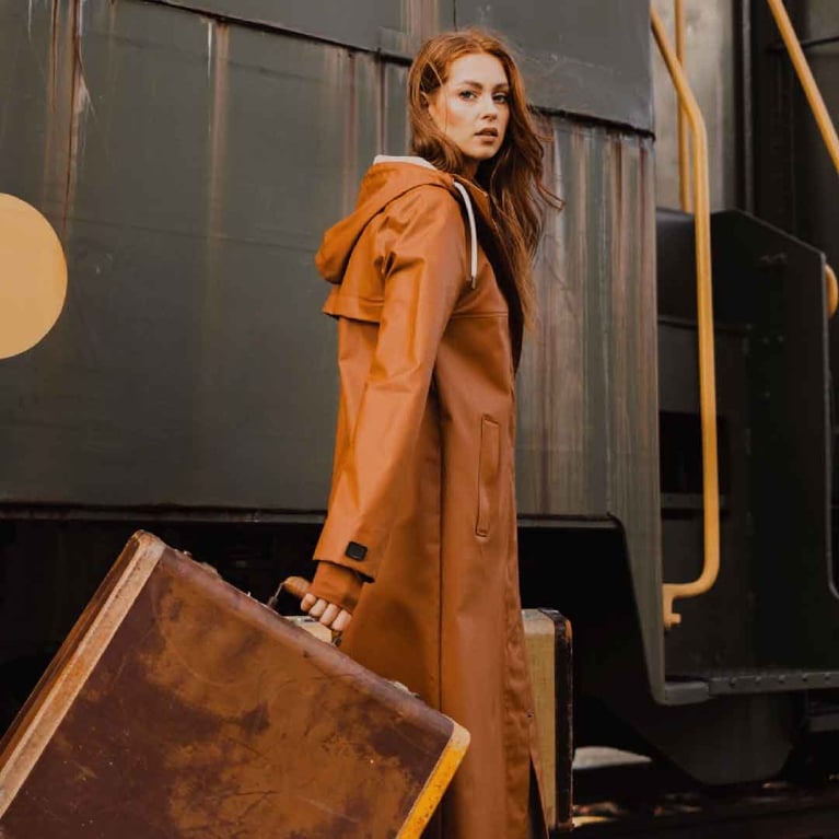 a model wearing a brown mernini raincoat