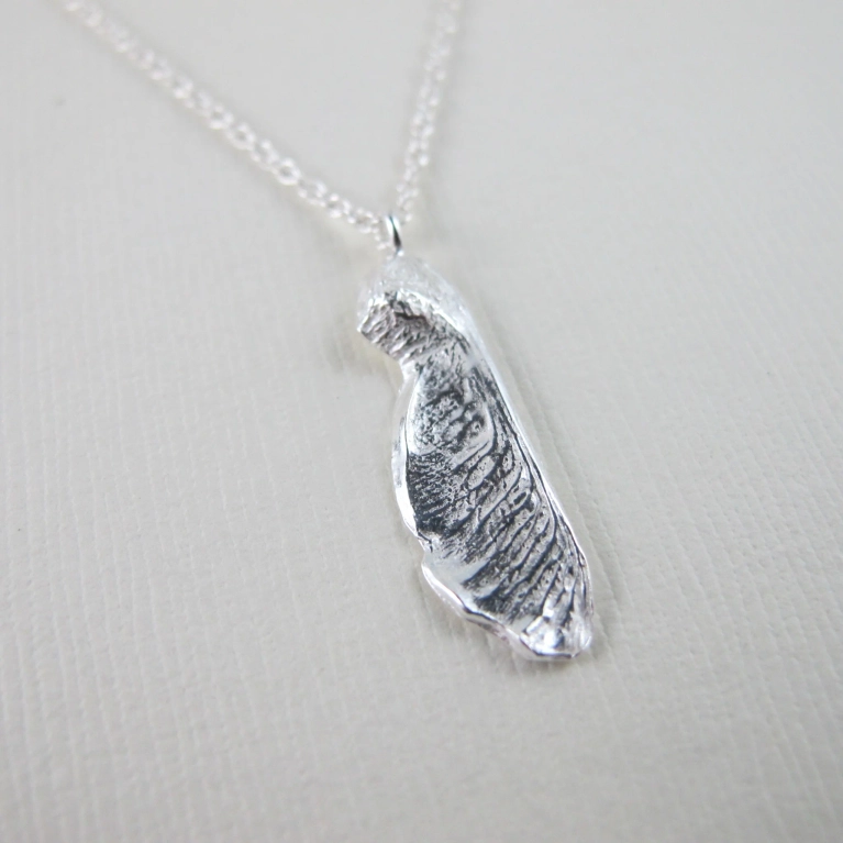 A silver maple key pendant necklace in a post about one of a kind christmas show.