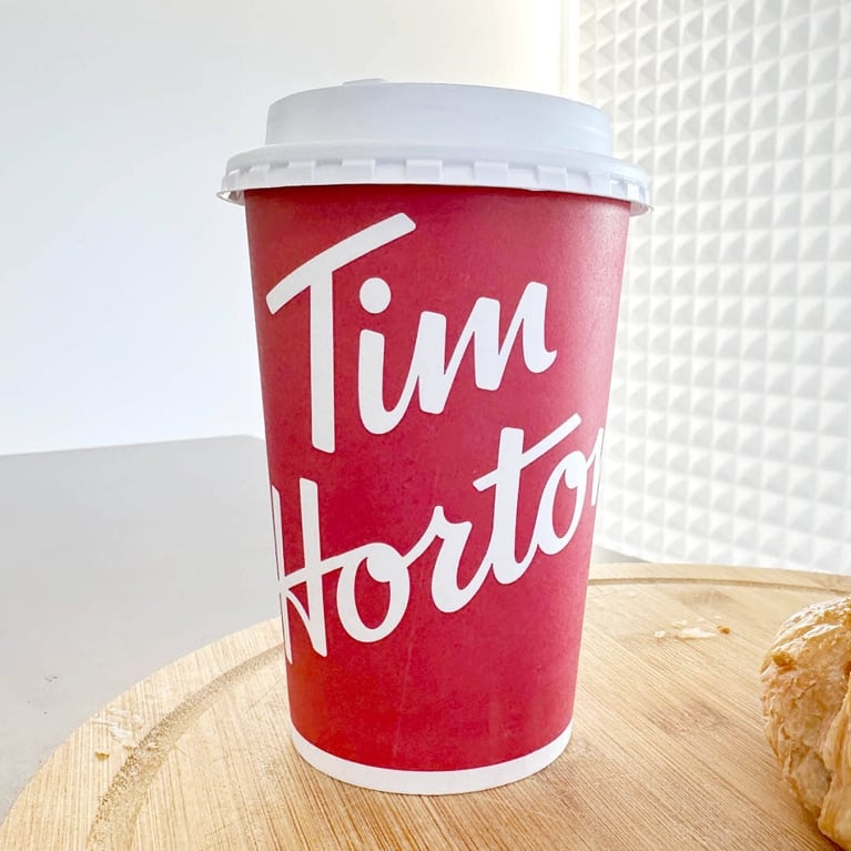 A red Tim Hortons hot drink cup in a post about Tim Hortons Biscoff.
