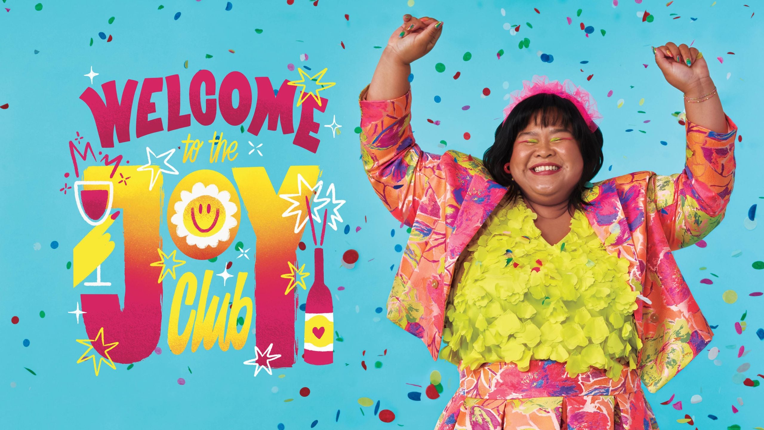 Comedian Ann Pornel raises her hands in the air and smiles as confetti drops around her, next to lettering that reads: "Welcome to the Joy Club," for a story about joy in 2025.